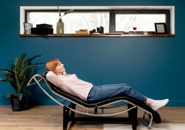 Free photo portrait woman at home relaxing on chair