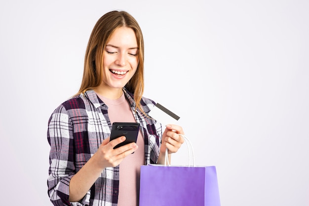 Portrait woman looking at phone and holding a bag