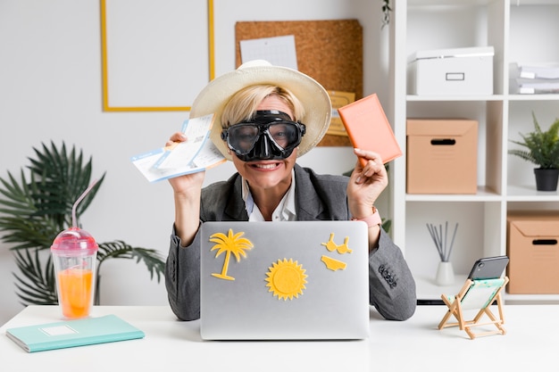 Free photo portrait of woman in office prepared for summer holiday