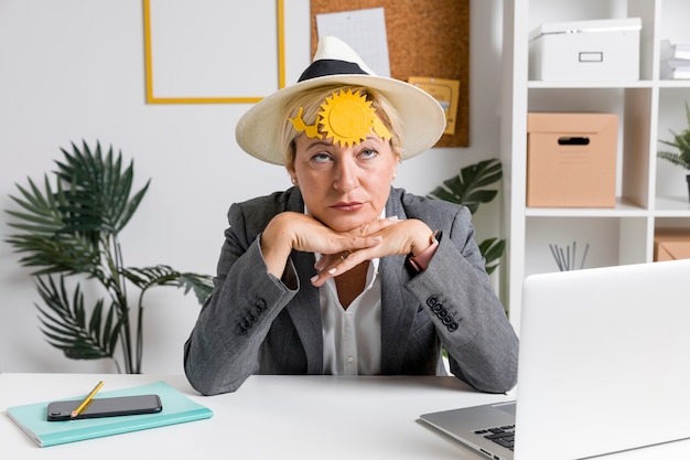 Portrait of woman in office prepared for summer holiday