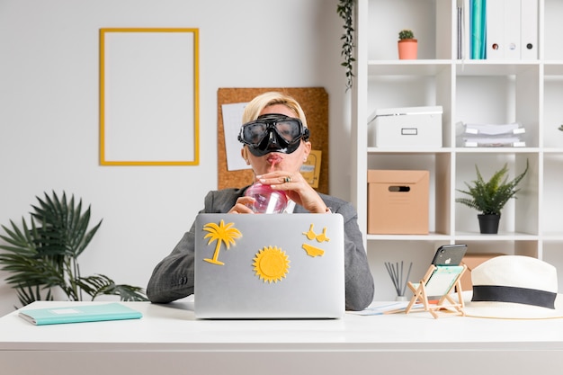 Free Photo portrait of woman in office prepared for summer holiday