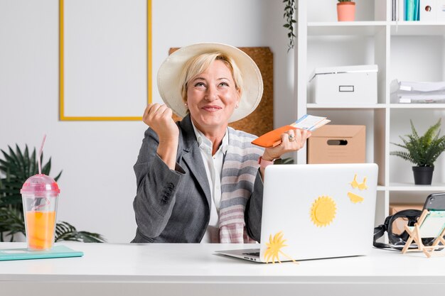 Portrait of woman in office prepared for summer holiday