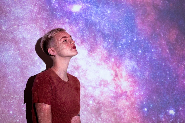 Free photo portrait of woman posing with universe projection texture