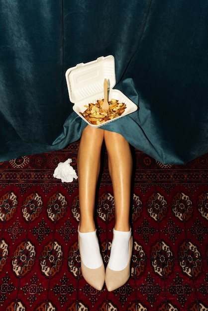 Free photo portrait of woman's legs with a dish of poutine