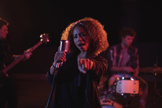 Portrait of woman singing on microphone