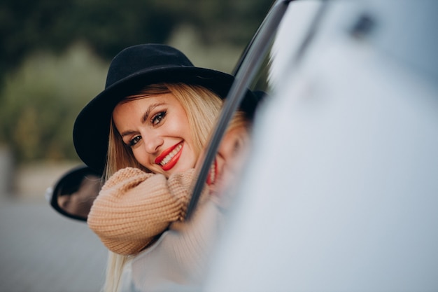 Free photo portrait of woman sitting in car and looking through the window