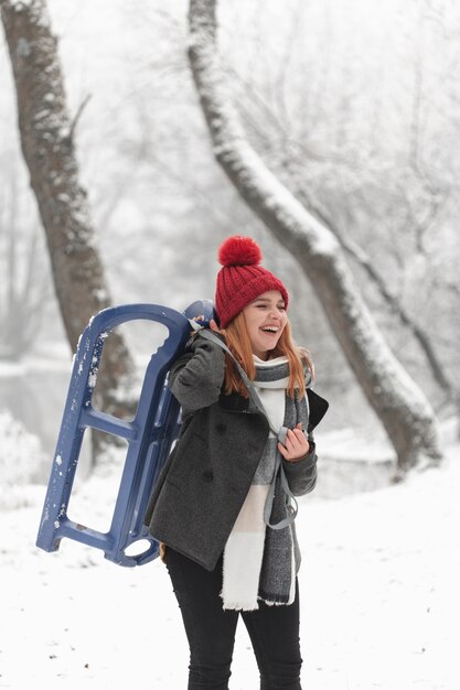 Portrait of woman and sleigh outdoors