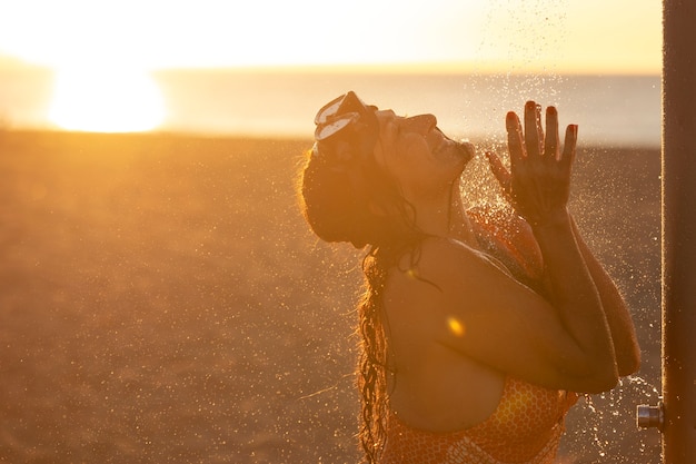 Portrait of woman taking a shower on the beach