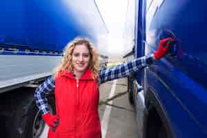 Free photo portrait of woman truck driver standing by truck vehicle