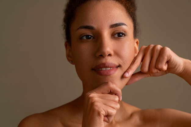 Free photo portrait of woman trying facial yoga massage to stay young