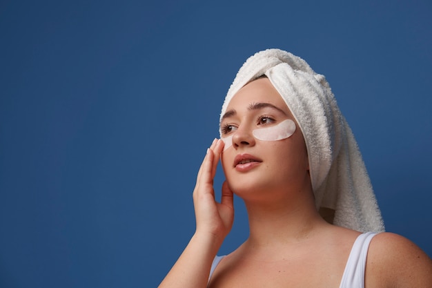 Portrait of woman using eye patches for beauty