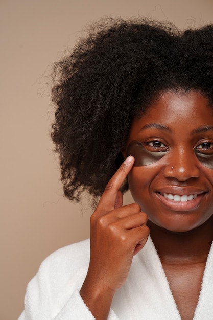 Portrait of woman using eye patches for beauty