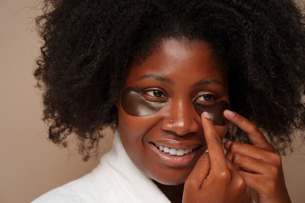 Portrait of woman using eye patches for beauty