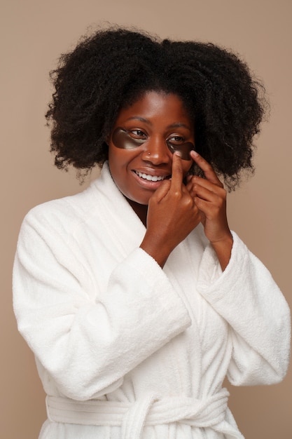 Portrait of woman using eye patches for beauty