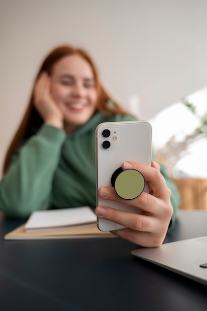 Portrait of woman using smartphone with pop socket outdoors