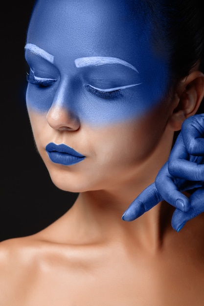 Free photo portrait of a woman who is covered with blue paint