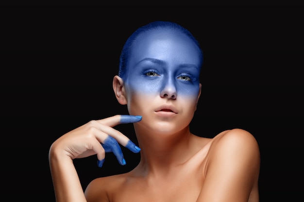 Portrait of a woman who is posing covered with blue paint