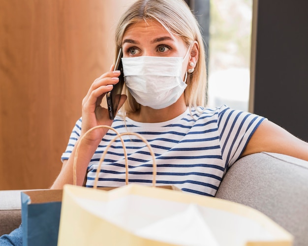 Portrait of woman with face mask talking on the phone