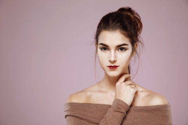 Portrait of woman with makeup posing on pink