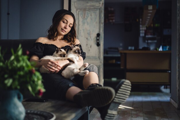 Portrait woman with Siamese cats