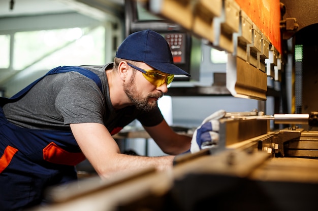 Free photo portrait of worker near metalworking machine