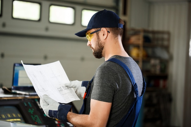 Free photo portrait of worker in overalls, steel factory background.