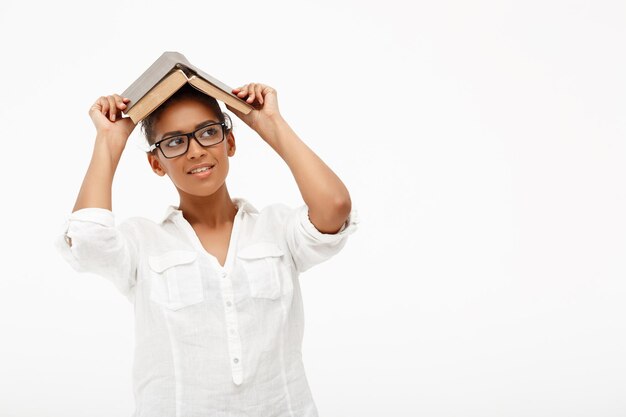 Portrait of young african girl with book over white background