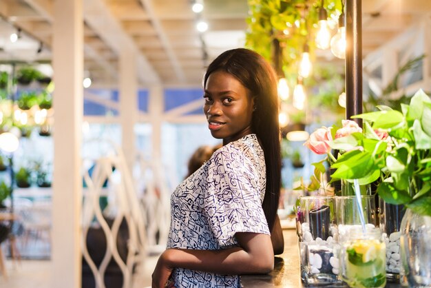 Portrait of young african woman standing in cafe