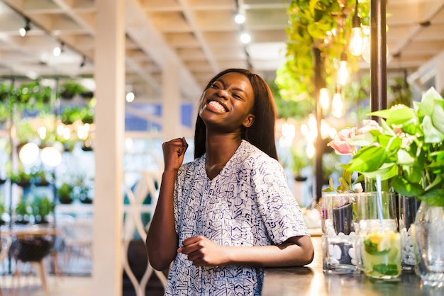 Portrait of young african woman standing in cafe