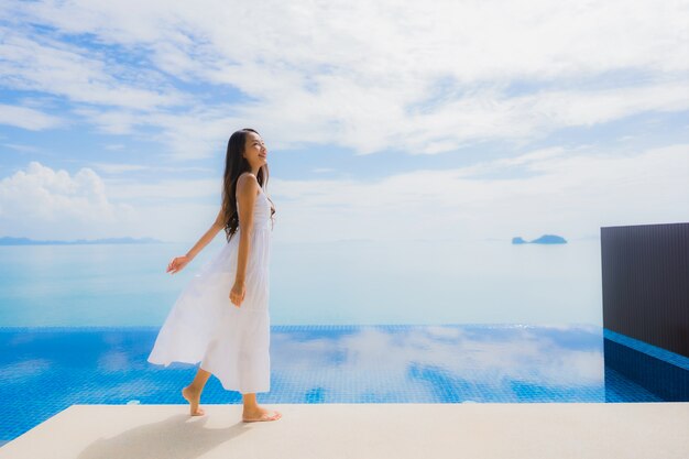 Portrait young asian woman relax smile happy around swimming pool in hotel and resort