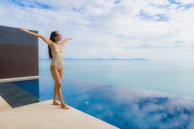 Portrait young asian woman relax smile happy around swimming pool in hotel and resort