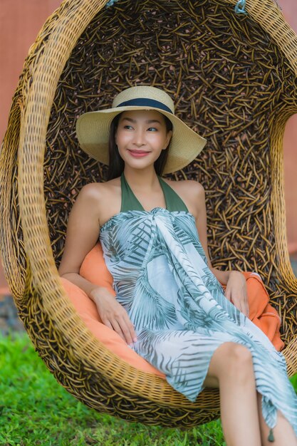 Portrait young asian woman sitting on swing chair in the garden