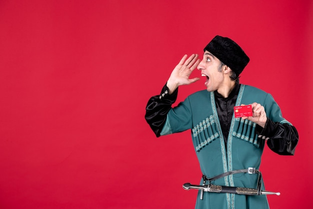 Free photo portrait of young azeri man in traditional costume holding credit card on red