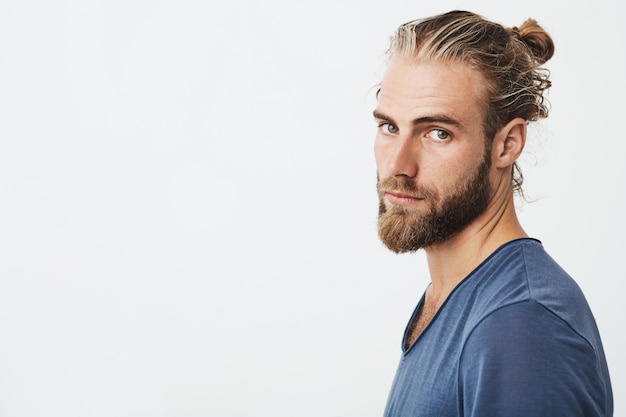 Portrait of young bearded guy with fashionable hairstyle and beard