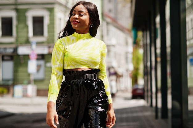 Free photo portrait of young beautiful african american fashion model woman wear in green top and black shiny wet look pants