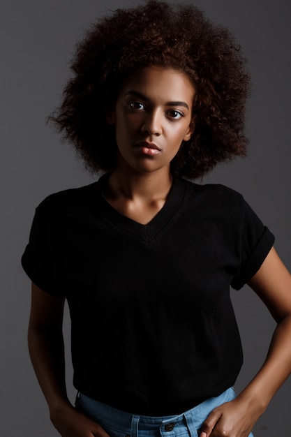 Portrait of young beautiful african girl  over dark wall