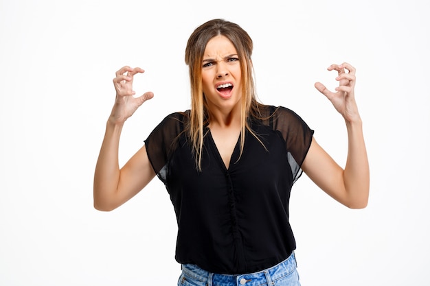 Portrait of young beautiful angry girl over white background.