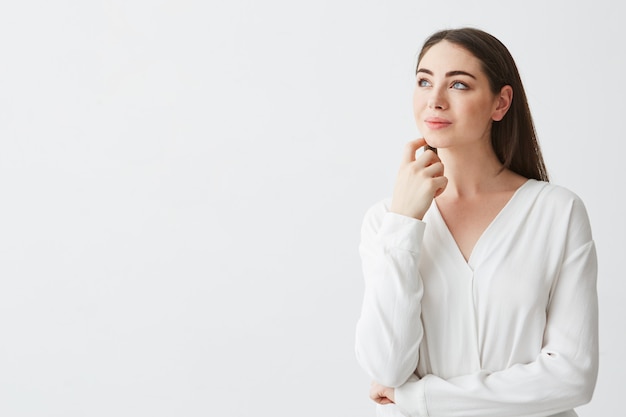 Portrait of young beautiful brunette businesswoman dreaming thinking frowning . Hand on chin.