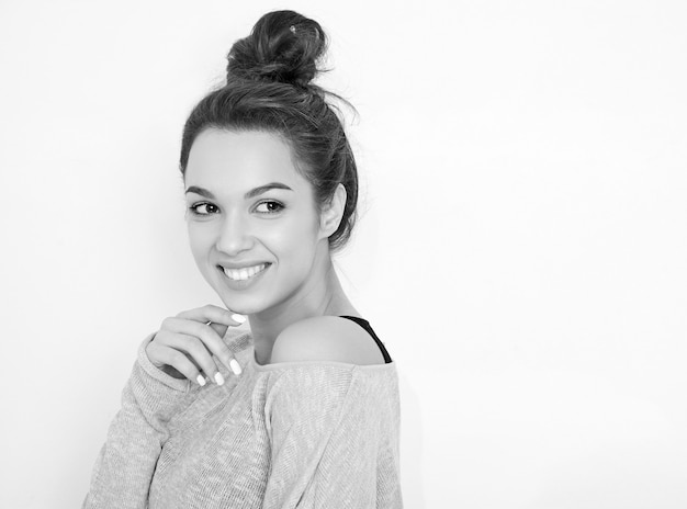 Portrait of young beautiful brunette woman girl model with nude makeup in summer clothes posing near wall. 