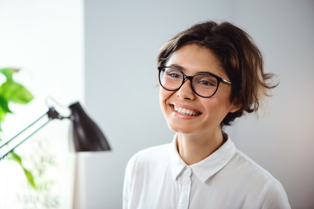 Portrait of young beautiful businesswoman smiling at workplace in office.