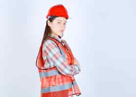 Free photo portrait of young beautiful female engineer in helmet posing to camera.