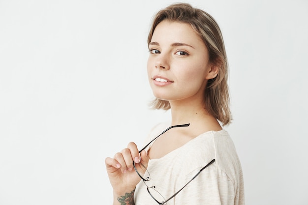 Portrait of young beautiful girl smiling holding glasses .