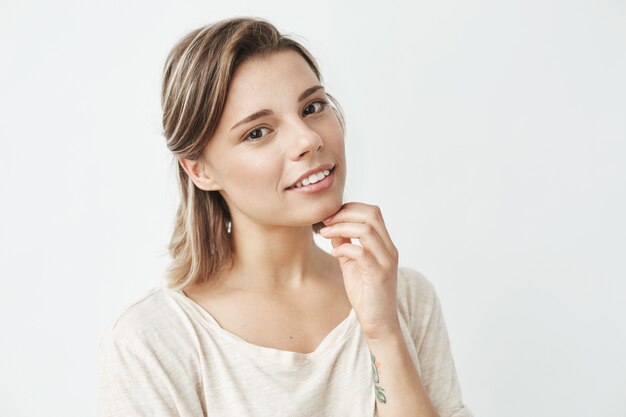 Portrait of young beautiful girl smiling holding hand on chin .