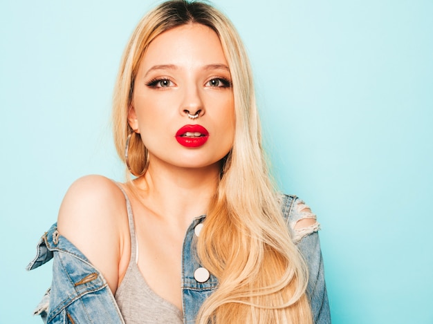 Free photo portrait of young beautiful hipster bad girl in trendy jeans  clothes and earring in her nose.  positive model having fun