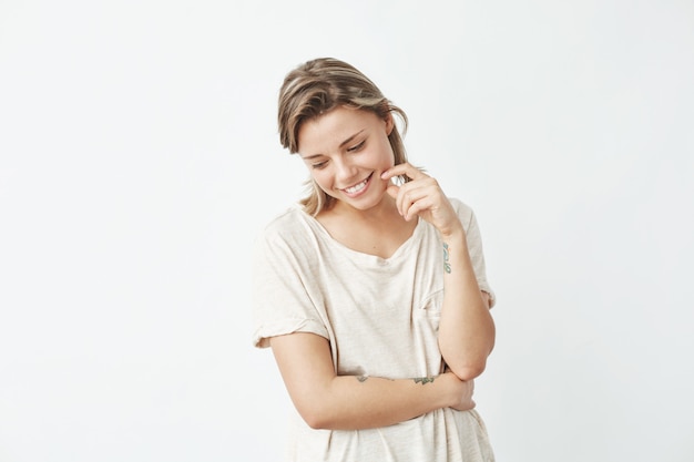 Portrait of young beautiful shy girl smiling looking down .