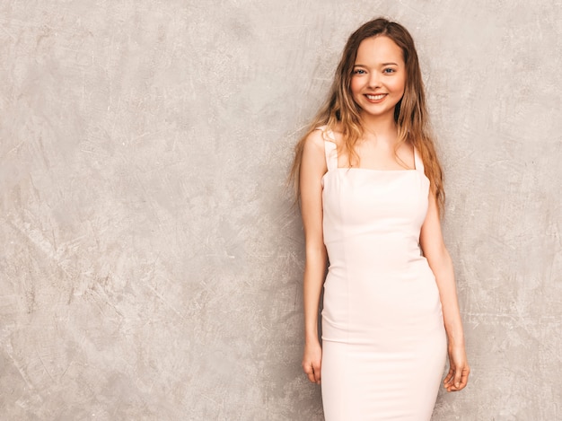 Free photo portrait of young beautiful smiling girl in trendy summer light pink dress. sexy carefree woman posing. positive model having fun