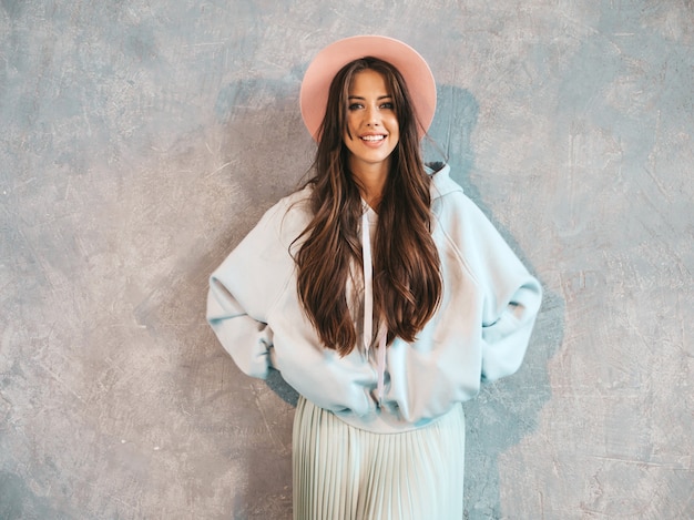 Portrait of young beautiful smiling woman looking . Trendy girl in casual summer hoodie and skirt clothes.  