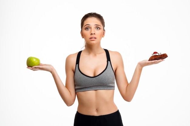 Portrait of young beautiful sportive girl over white background.