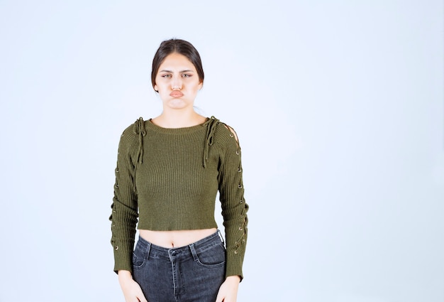 Free photo portrait of a young beautiful woman model standing and posing over white wall.