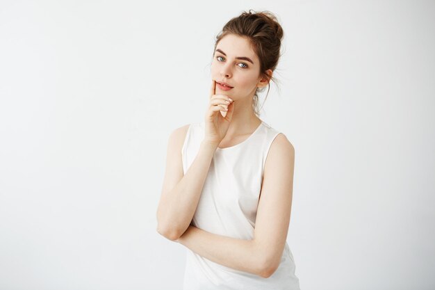 Portrait of young beautiful woman smiling touching her chin.